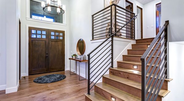 Chic entrance foyer with high ceiling and wide staircase with lights and contemporary railing. New Custom built home interior in Annapolis Maryland.
